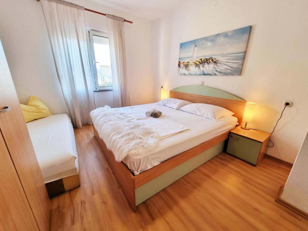 苏佩塔斯卡德拉加Apartment in Supetarska Draga with sea view, terrace, air conditioning, WiFi 4551-3的一间卧室,卧室里配有一张床,猫坐在床上