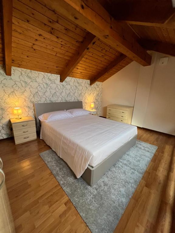 比耶拉V HOME的卧室设有白色大床和木制天花板。