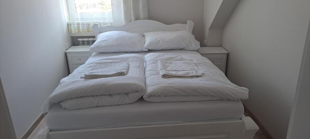 Rycerka GórnaApartament Magurka 1的一张带白色毯子和枕头的床