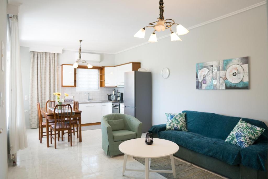蒂锡利维Raptis Guest House的客厅配有蓝色的沙发和桌子