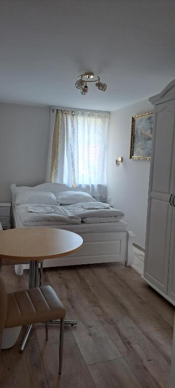 Rycerka GórnaMagurka的卧室配有一张床,窗户前设有一张桌子