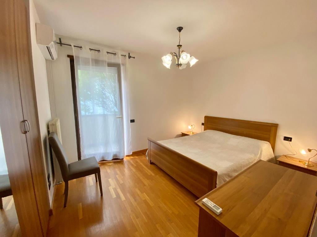 加尔达湖滨My House的一间卧室配有一张床、一张桌子和一个窗户。
