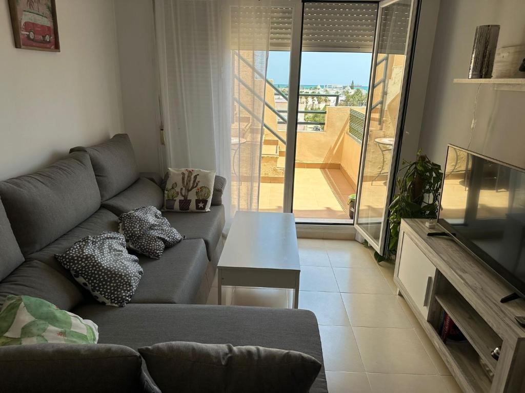 维拉Ático con piscina privada vistas al mar.的带沙发的客厅和阳台美景