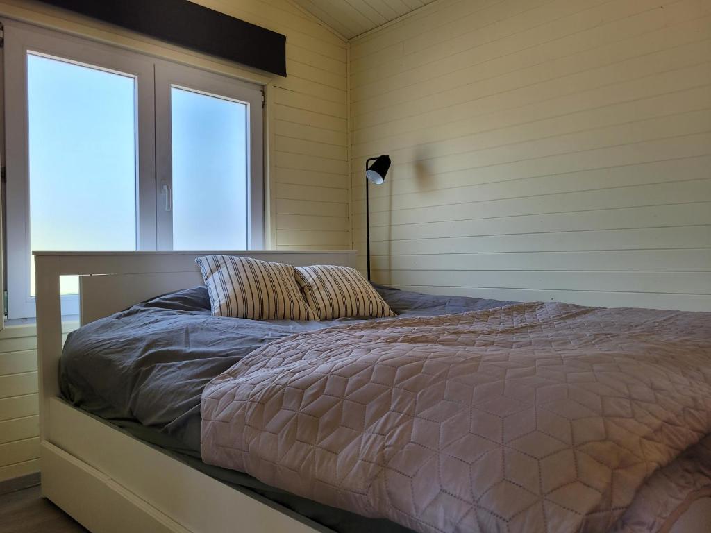赫尔Rustig gelegen chalet Solvo met terras aan het water的一间带床的卧室,位于带窗户的房间内