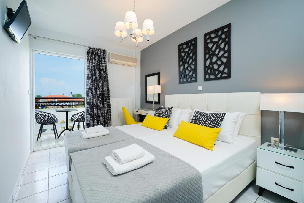 萨索斯Studios Paradise的卧室配有一张带黄色枕头的大型白色床。