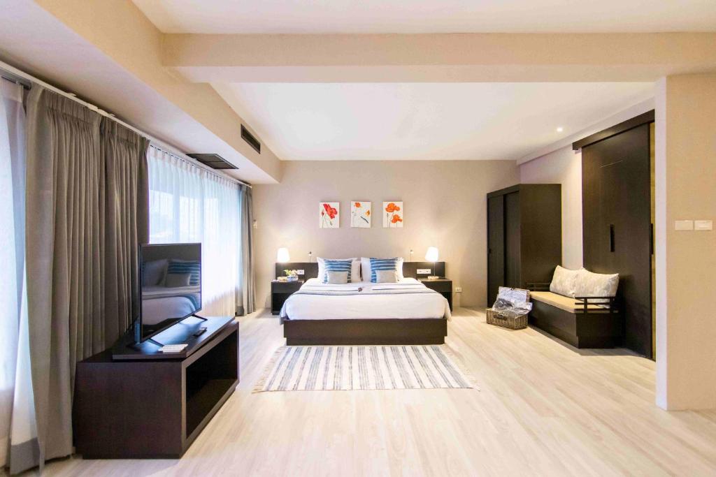 乌汶Tohsang Heritage Ubon Ratchathani Hotel的一间大卧室,配有一张床和一张沙发