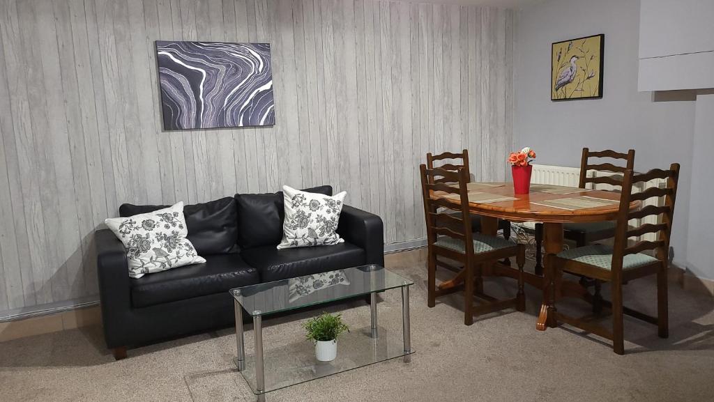 布里斯托Fully Furnished 3 bedroom Appartment的客厅配有黑色沙发和桌子
