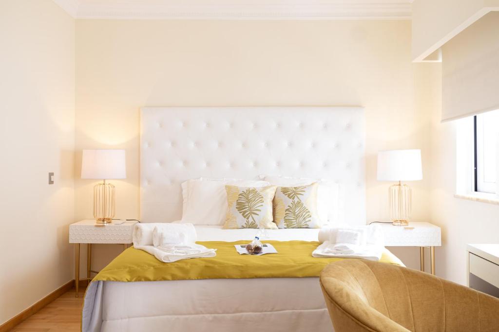法鲁Sunny, The House - AL的白色卧室配有一张带黄色床单的大床