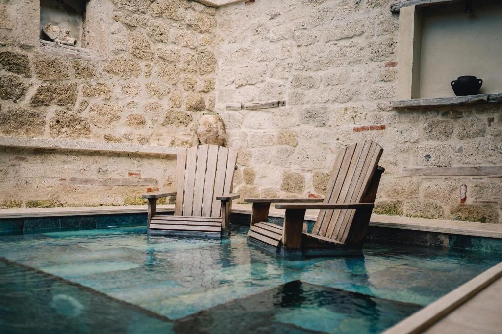 阿拉恰特Suare Alaçatı的游泳池内的两把椅子和一张桌子