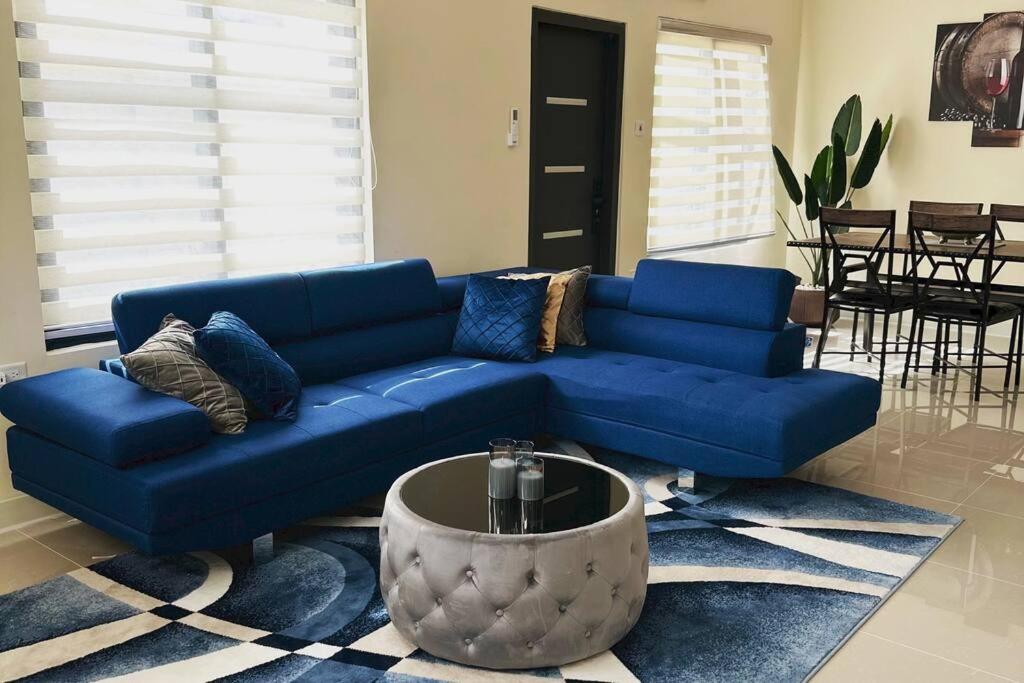 欧丘里欧Casa Bella Vista @ Pyramid Point的客厅配有一张蓝色的沙发,配有一张桌子