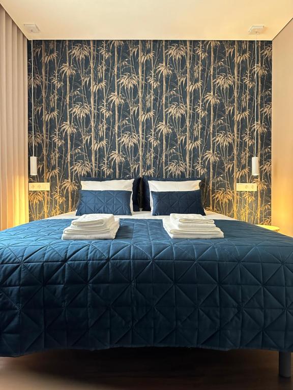 加亚新城House Real Companhia的一间卧室配有一张蓝色的床和壁纸