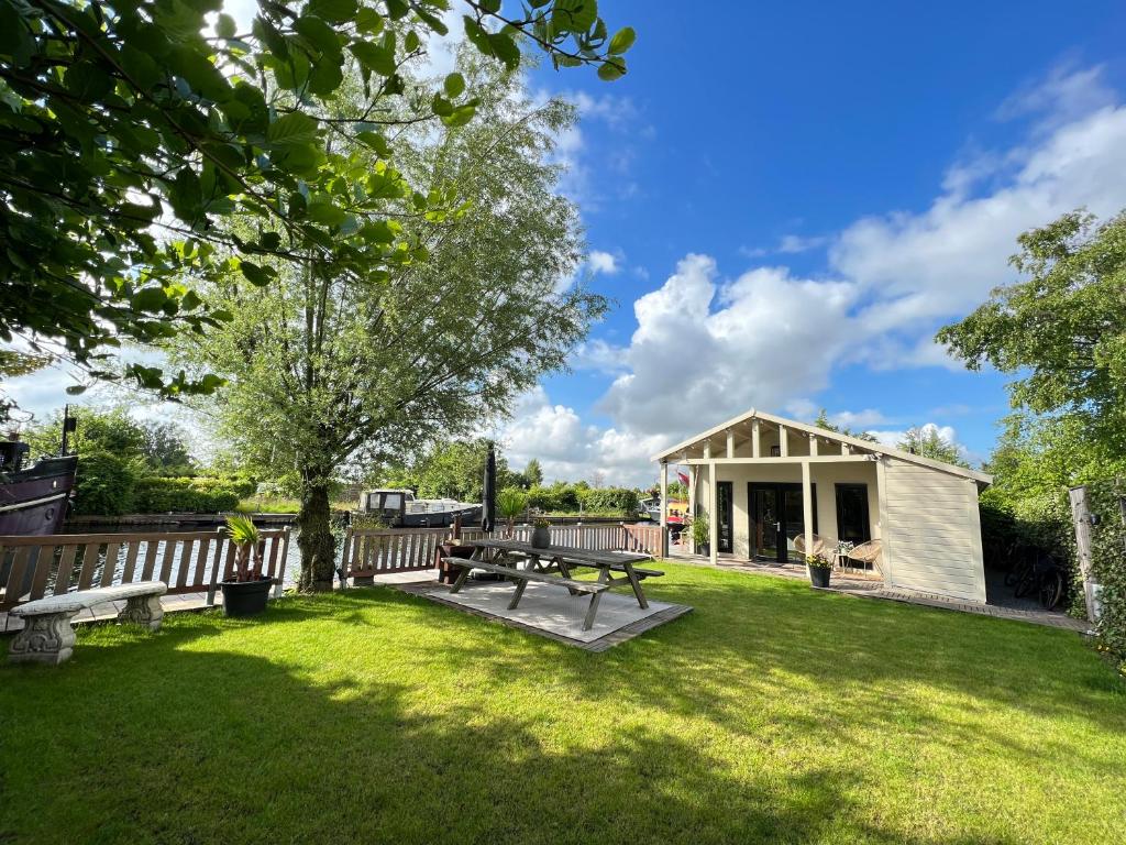 芬克芬NEW - Private Cabin - on a lake near Amsterdam的野餐桌和长凳,在带建筑物的院子内