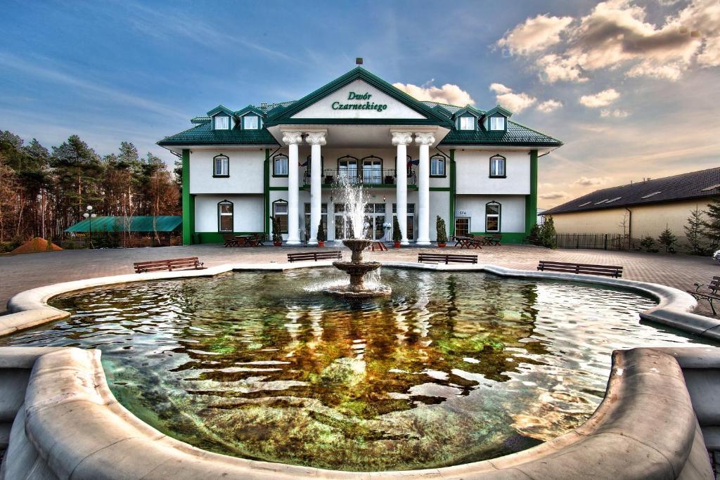 比亚韦斯托克瓦恰米切赫酒店的建筑物前方有喷泉的建筑物