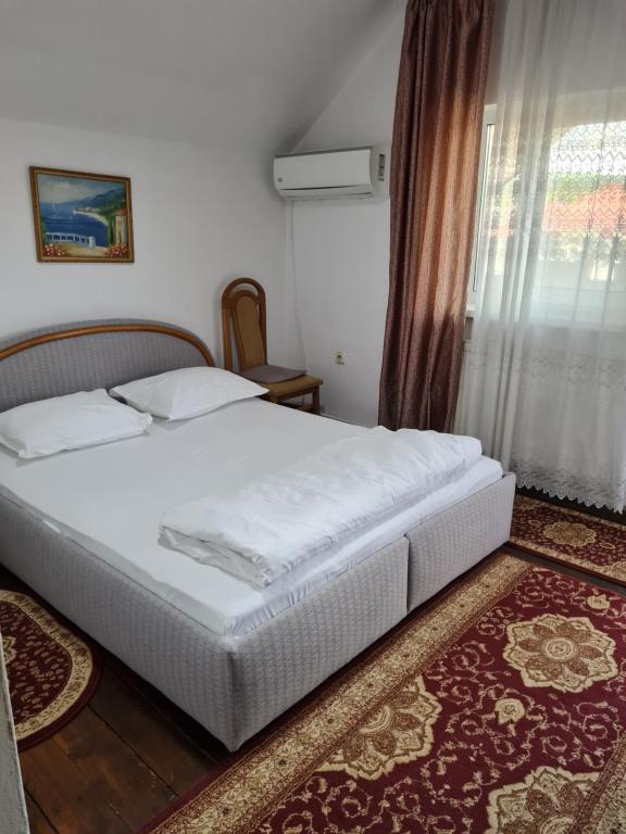 GherlaPensiunea Clasic的卧室配有白色的床和窗户。