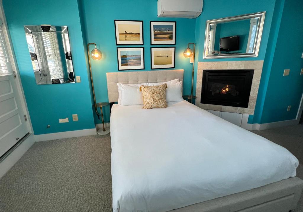 普罗温斯敦Lotus Provincetown的蓝色卧室设有一张床和一个壁炉
