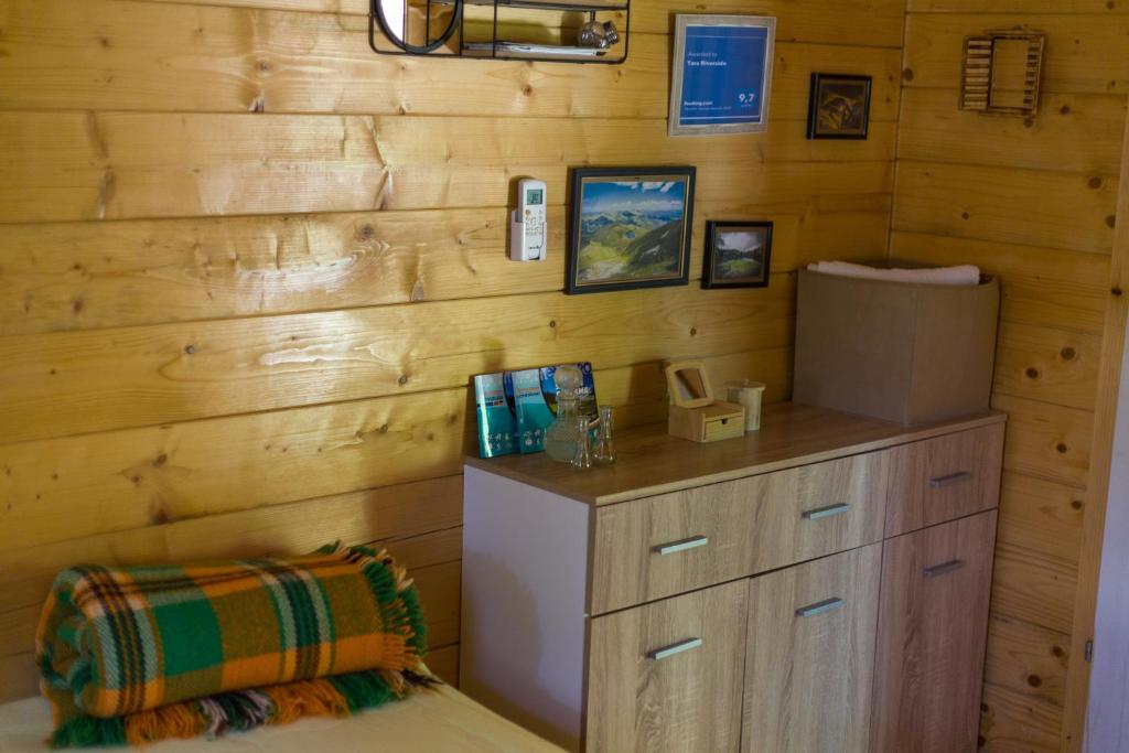 莫伊科瓦茨Tara Riverside的客房设有带冰箱的木墙