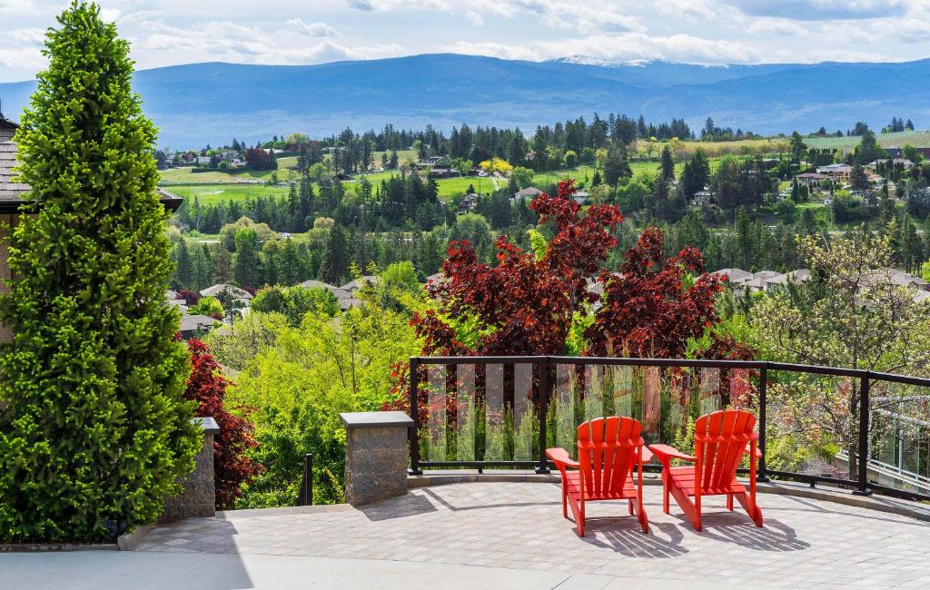 西基隆拿Sunrise Valley Suite的美景庭院设有两张红色椅子和一张桌子