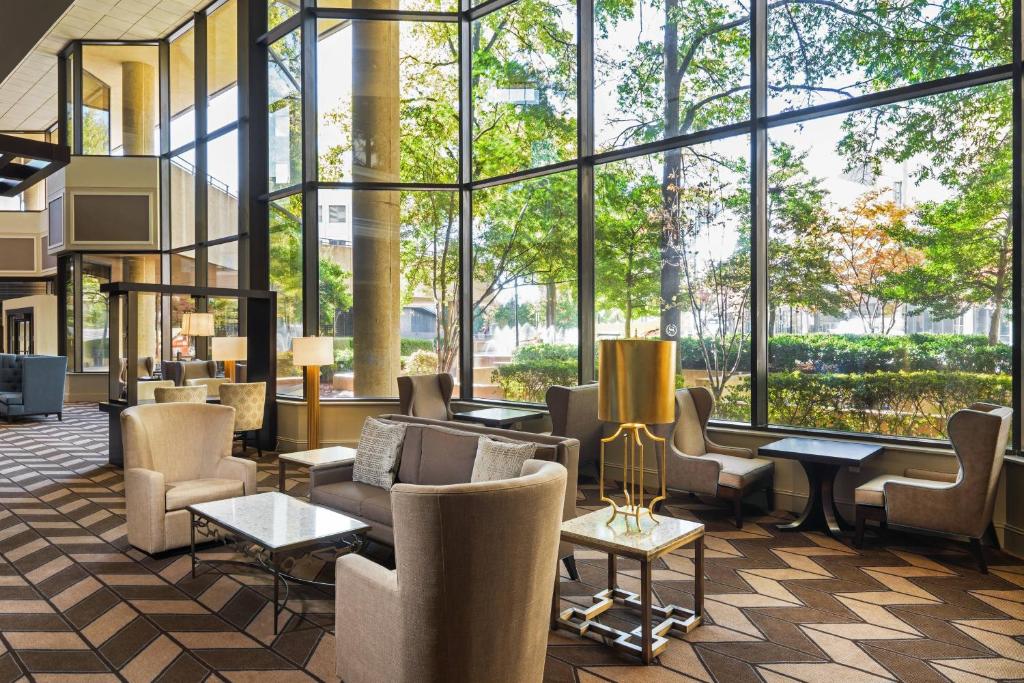 孟菲斯Sheraton Memphis Downtown Hotel的大堂设有桌椅和大窗户。
