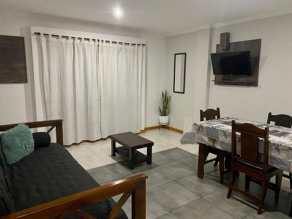 伊瓜苏港Santino Apart的客厅配有桌子、沙发和电视