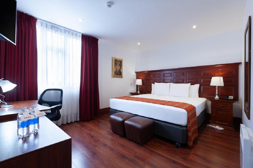 库斯科泰拉安迪纳殖民地庄园酒店的酒店客房设有一张大床和一张书桌。