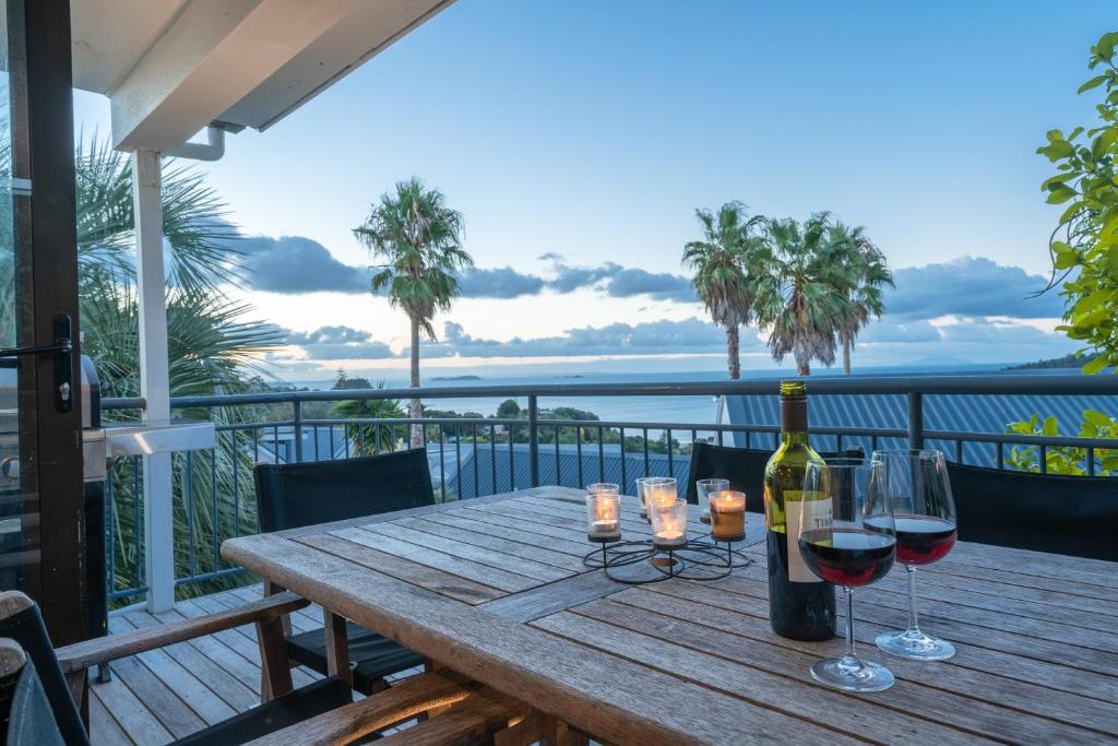 棕榈滩2 bdrm,2 level Cottage, Kayaks, SKY TV, Wifi(Car?)的阳台上的木桌和两杯葡萄酒