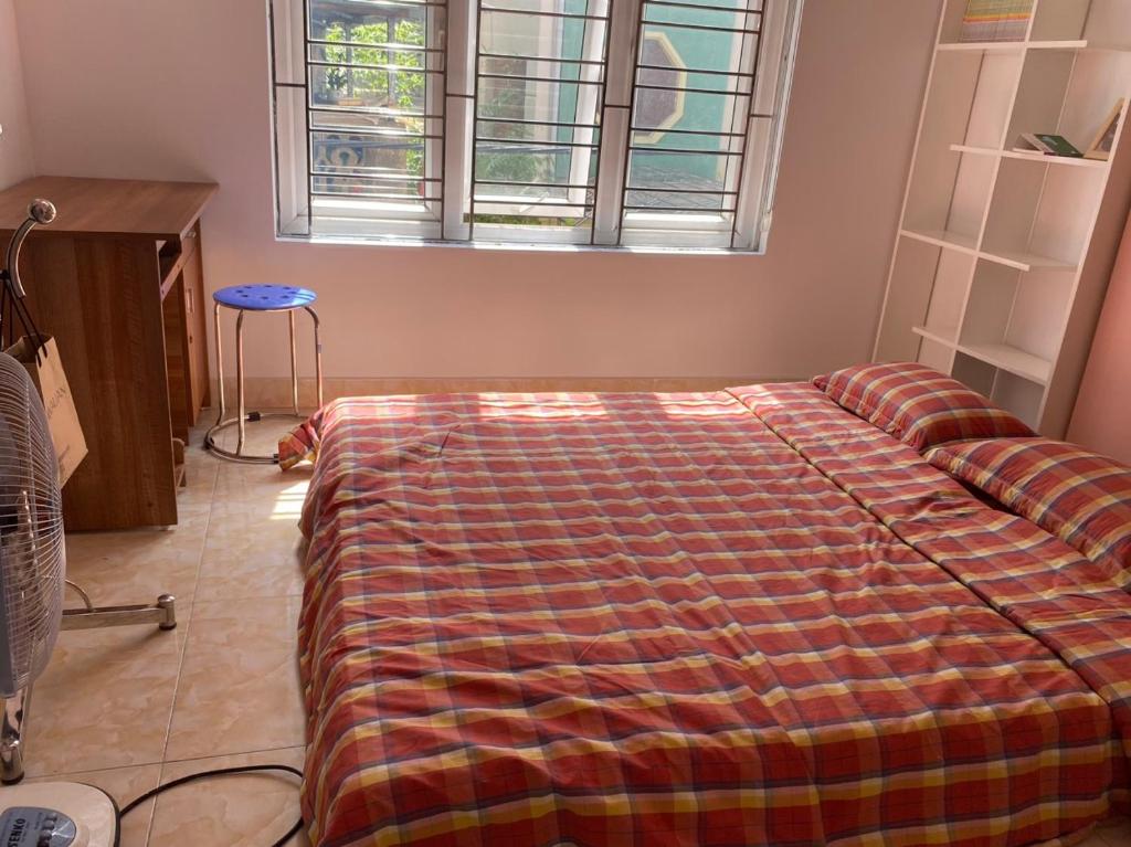 海防GM Homestay的一间卧室配有一张床铺,床上有毯子