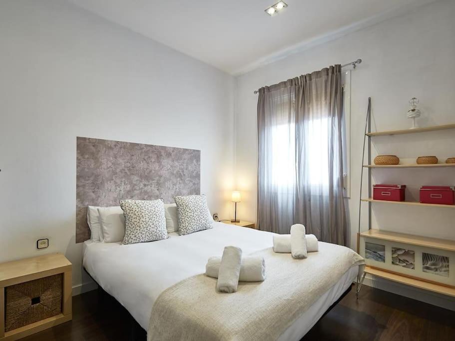 巴塞罗那Bed&BCN Arquimedes Barcelona的一间卧室配有一张大床和两条毛巾