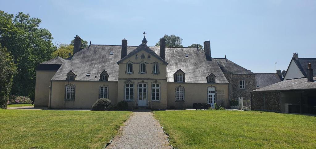 Manoir de Saint Ouen的前面有草地的老房子