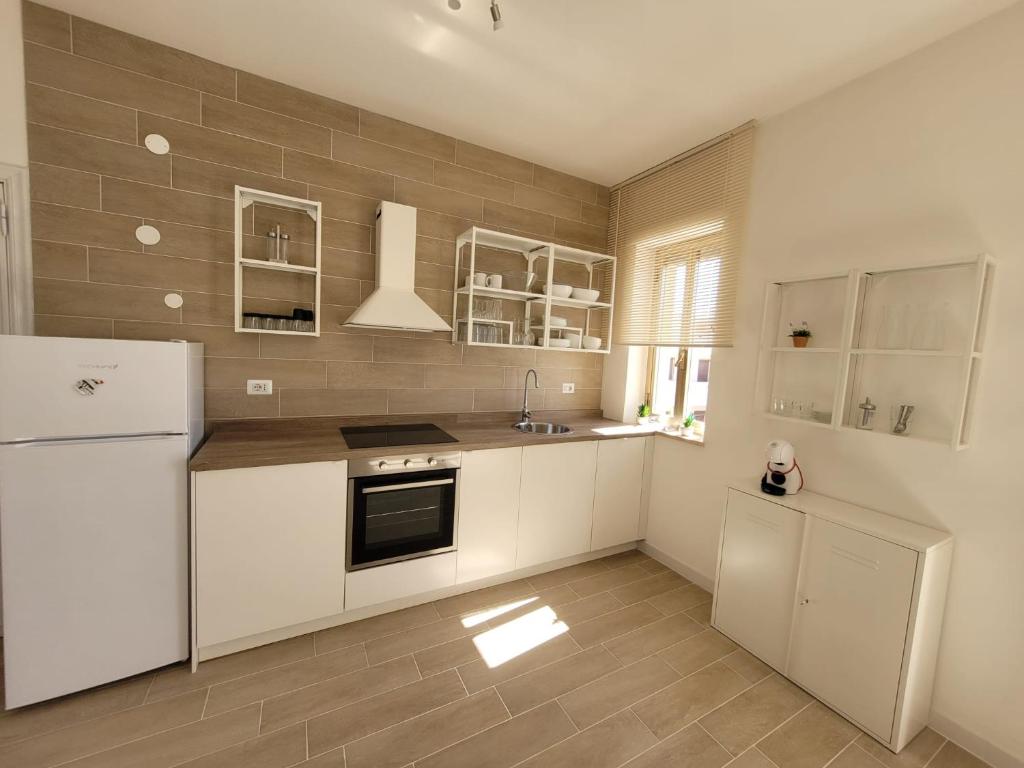 丽都玛里尼Appartamento Demetrio 50m mare & shopping的厨房配有白色橱柜和冰箱。