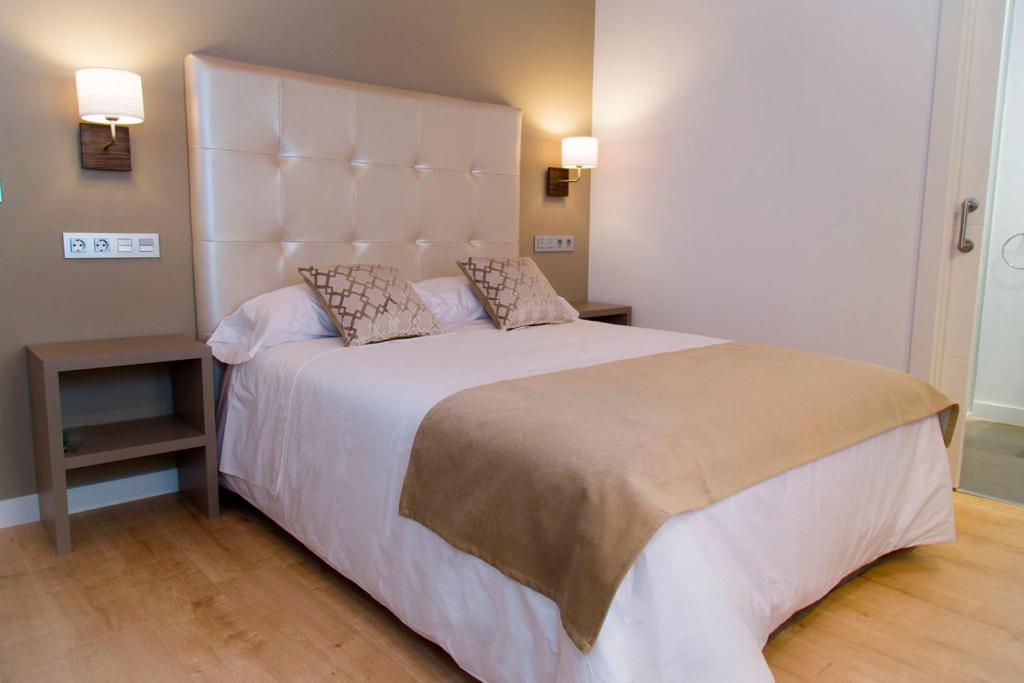 塞哥维亚哈卜城市旅舍的一间卧室配有一张大床和大床头板