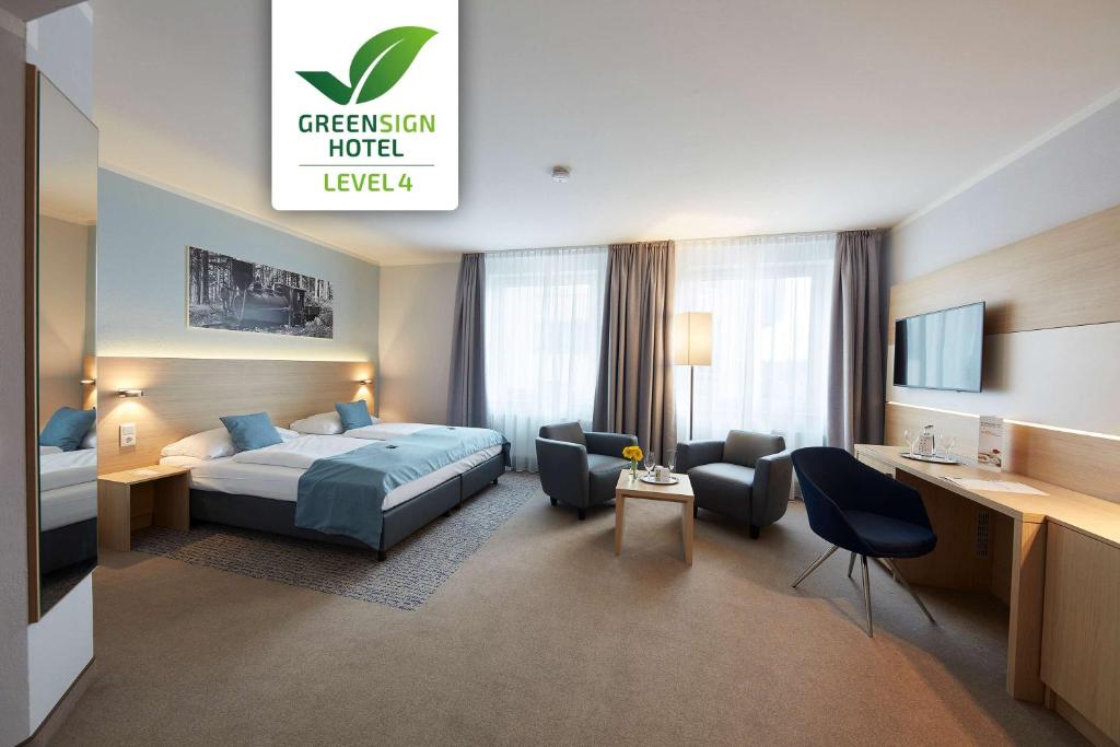 哥廷根GHOTEL hotel & living Göttingen的配有一张床和一张书桌的酒店客房