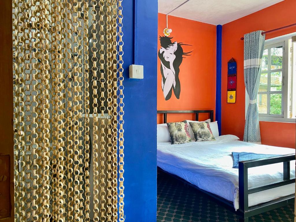 加德满都Yog Hostel的一间卧室设有一张床和橙色的墙壁