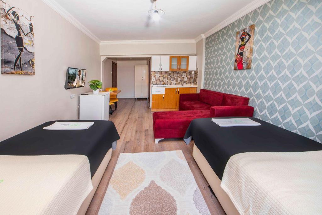 开塞利Seyir Evleri DİVAN的客厅配有两张床和一张红色沙发