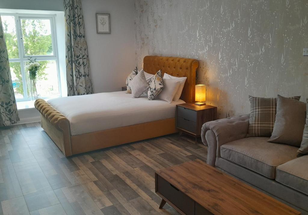 威德尼斯The Hillcrest Hotel的一间卧室配有一张床、一张沙发和一张桌子