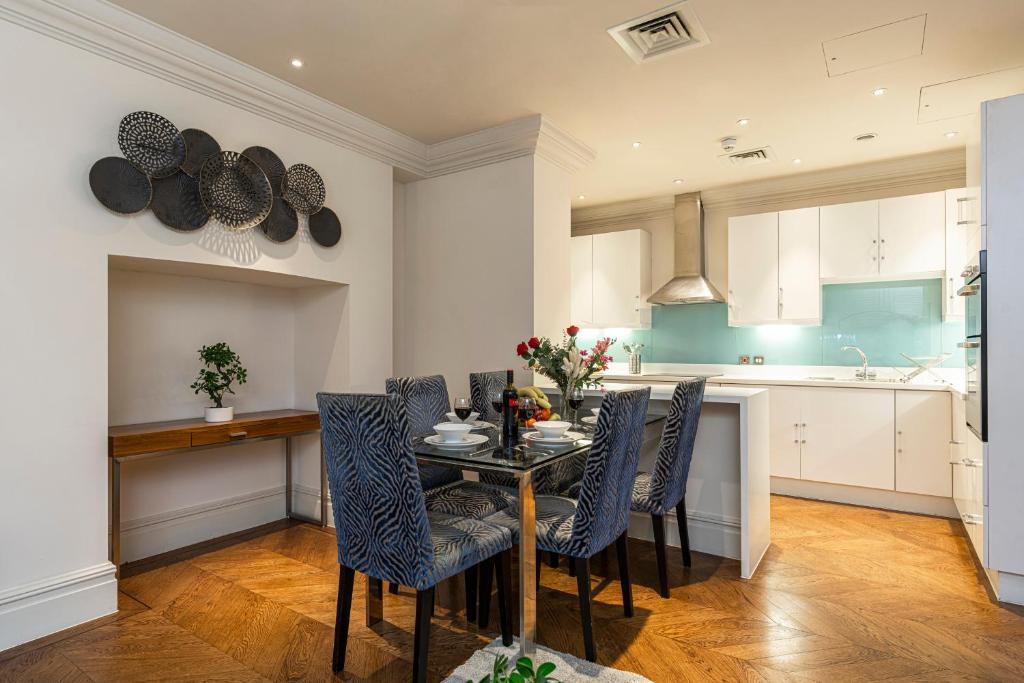 伦敦Grosvenor Mayfair的厨房里设有1间带桌椅的用餐室