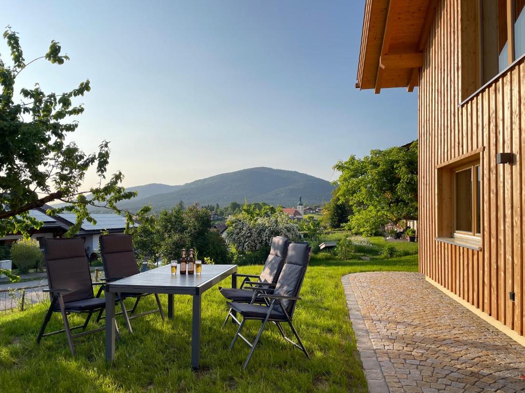 阿尔恩布鲁克Bayerwald Chalet Kaitersberg mit Sauna, Sonnenterrasse und Garten的草地上带桌椅的天井