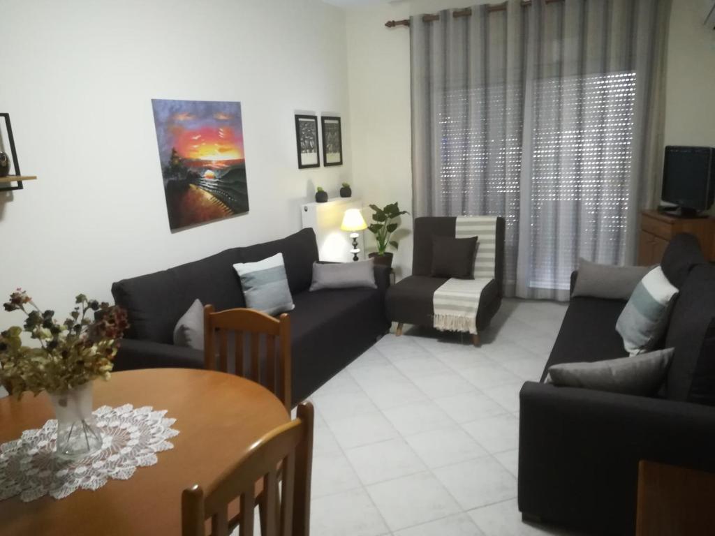Néa KhilíΔιαμέρισμα σε πολυκατοικία的客厅配有沙发和桌子
