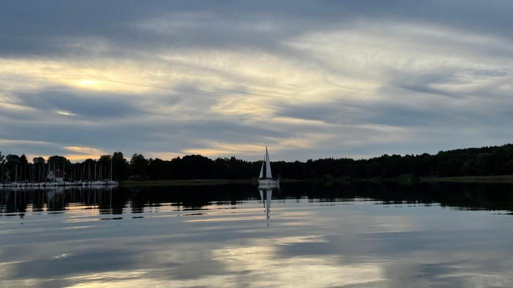 BogaczewoDom wakacyjny Bogaczewo的湖上水中的帆船
