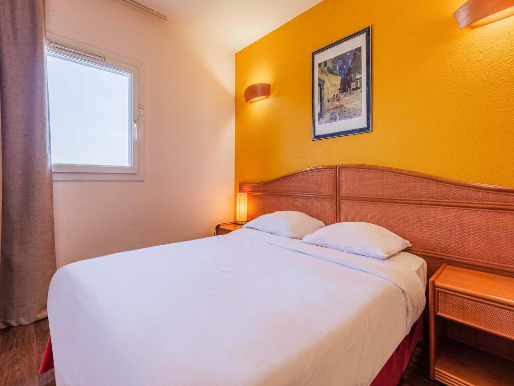 奥尔泽姆B&B HOTEL Strasbourg Aéroport的卧室配有白色的床和黄色的墙壁