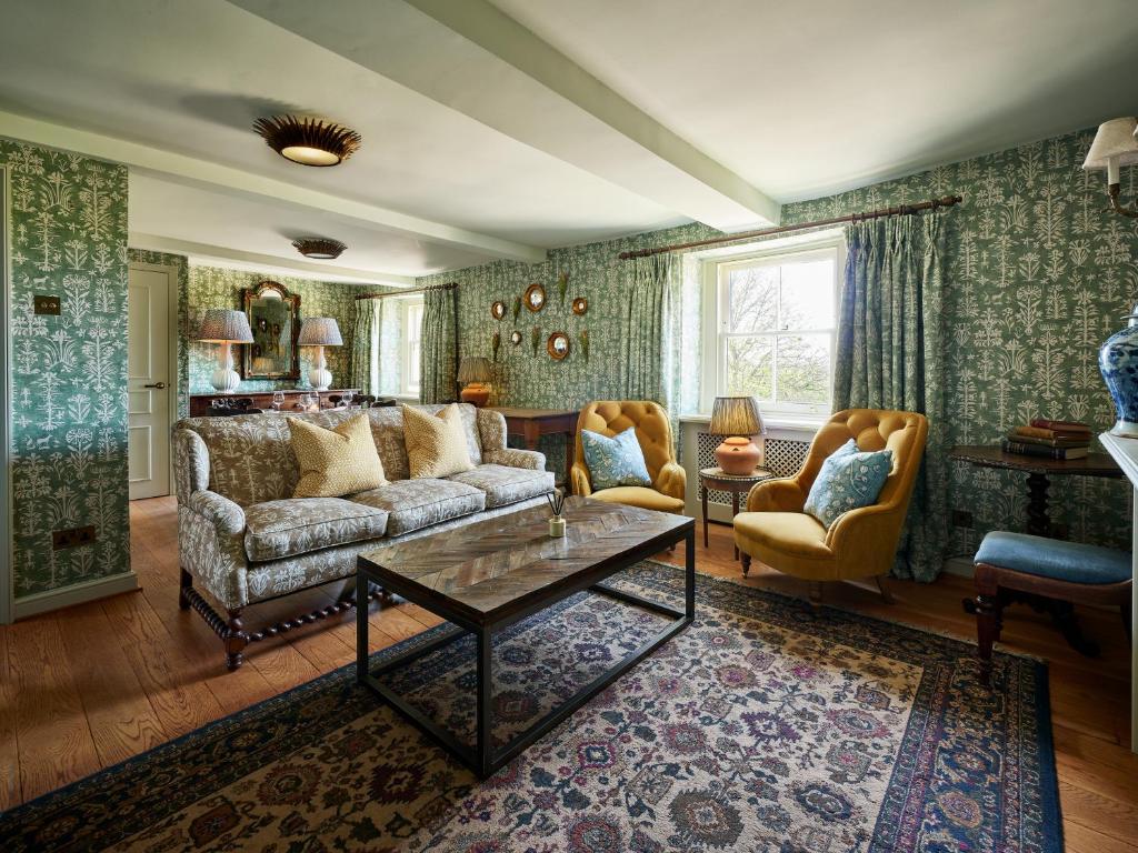 马姆斯伯里Townhouse Suites- Abbey Row的客厅配有沙发和两把椅子
