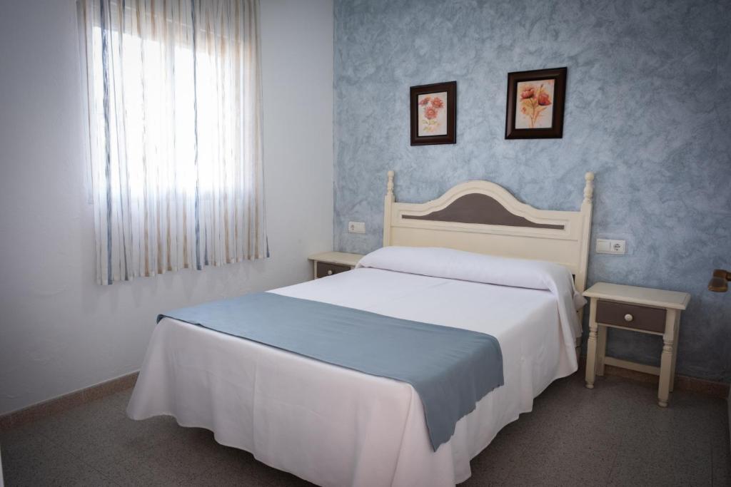 科尼尔-德拉弗龙特拉图里斯提克斯卡波罗施公寓酒店的卧室设有一张白色大床和一扇窗户。