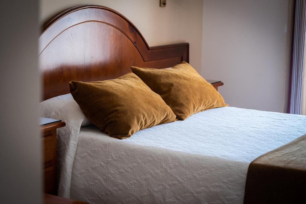 科尼尔-德拉弗龙特拉凯博罗氏旅馆的一张带木制床头板和两个枕头的床