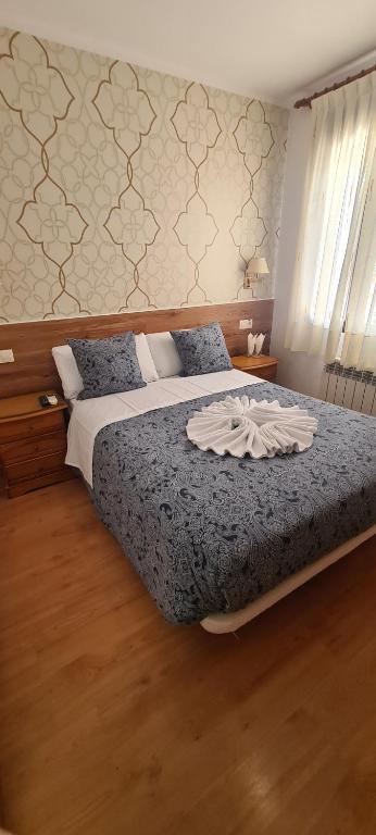 马德里Salomé的一间卧室配有一张带蓝色棉被的床