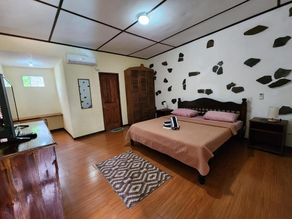 邦劳提普托普酒店的一间卧室配有一张床和一台电视,铺有木地板