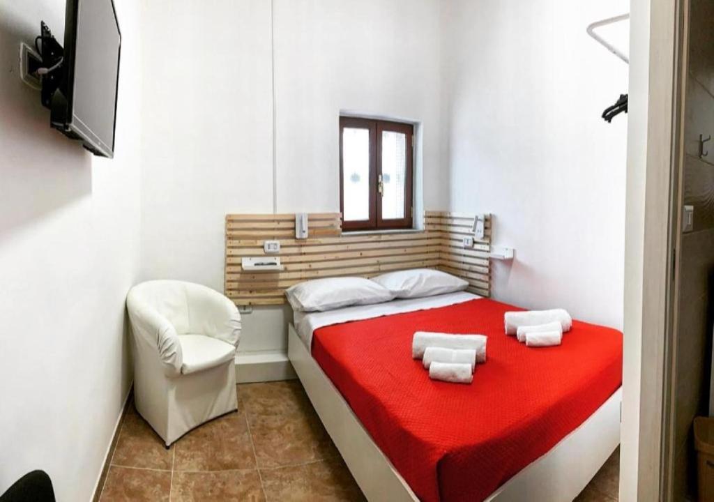 那不勒斯MIRIS home fast and comfortable with self check in 8 minutes walk near Naples airport的一间卧室配有一张带红色毯子和椅子的床