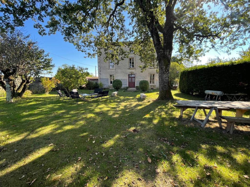 拉克雷奇Maison de maître aux portes du Marais poitevin的白色房子前面的野餐桌