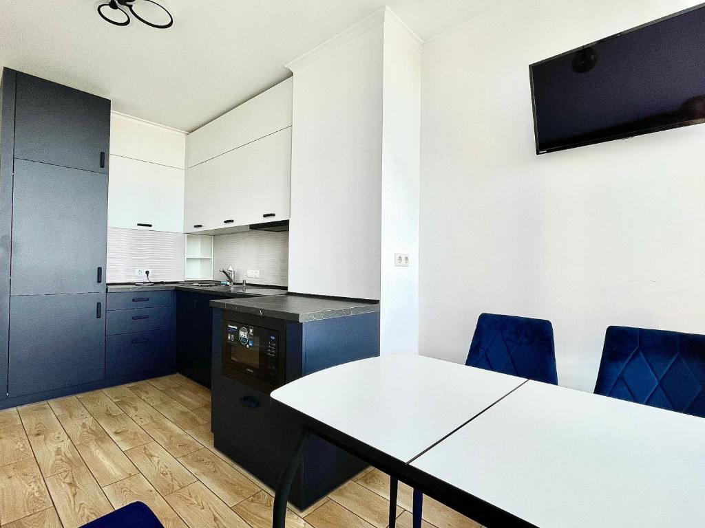 切尔卡瑟1-к квартира люкс з видом на Дніпро的厨房配有白色的桌子和蓝色的椅子