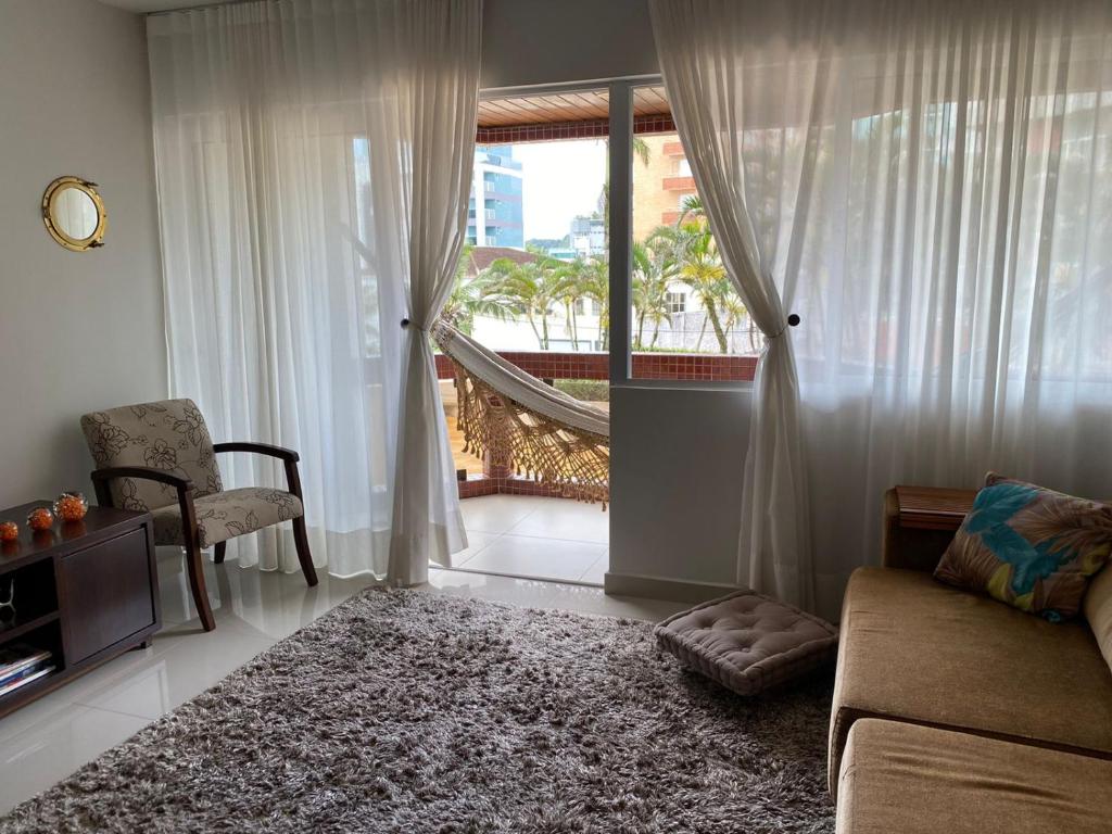马蒂尼奥斯Apto todo equipado em Caiobá há 50m do mar的带沙发、椅子和窗户的客厅
