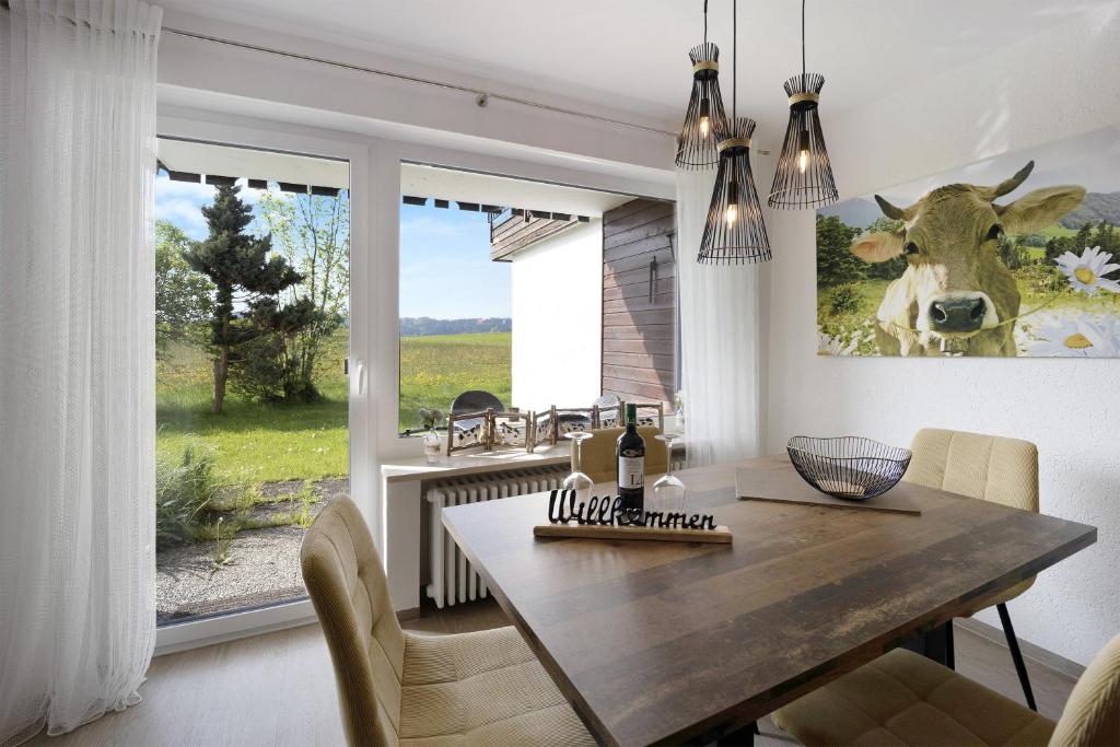Landliebe mit Seenähe und Innenpool的用餐室配有桌子和墙上的牛图片