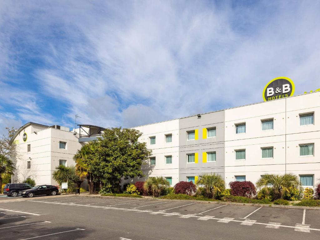 雷恩B&B HOTEL Rennes Sud Chantepie的白色的建筑,旁边标有标志